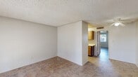Located at 844 East Bell Road in Phoenix, AZ, this single-story, one-bedroom, two-bathroom unit offers a practical and well-organized layout across a compact footprint. The living room is a welcoming open space featuring textured ceilings, neutral walls, and tile-style flooring that runs throughout the unit. A standout feature is the set of French doors that flood the living area with natural light and provide views of the surrounding outdoor greenery. The combined dining and kitchen area is positioned centrally, with warm-toned wood cabinetry, a white appliance suite including a range and refrigerator, and a window that brings in additional natural light. The bedroom is a comfortable, well-proportioned retreat with a window overlooking the exterior, neutral finishes, and two sliding closet doors that provide generous storage. A third closet is accessible elsewhere in the unit, adding further storage flexibility. The two bathrooms are functionally designed; one features a full tub-shower combination with a safety grab bar, neutral surround panels, and tile-style flooring, while the second includes a vanity with under-sink cabinetry. Textured ceilings are consistent throughout, and the overall color palette of whites and warm neutrals gives the space a clean, straightforward character suited for everyday living.