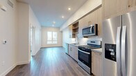 Located in the heart of Los Angeles at 1340 S Hill St, this thoughtfully designed one-bedroom, one-bathroom residence offers a modern and efficient layout across a single floor. The open-concept living and kitchen area creates a welcoming flow, anchored by warm hardwood-style flooring that runs throughout the unit. The kitchen is a standout feature, equipped with a full suite of stainless steel appliances — including a gas range, built-in microwave, dishwasher, and French door refrigerator — complemented by light wood cabinetry, open shelving, a white subway tile backsplash, and a sleek undermount sink. Recessed lighting illuminates the space, enhancing the clean, contemporary aesthetic. The bedroom offers a quiet retreat with a large window that frames views of the surrounding cityscape, filling the room with natural light. A stylish barn-style sliding door adds a modern architectural touch. The bathroom is elegantly appointed with a wood-toned vanity, quartz countertop, gold-accented mirrors and fixtures, and tile flooring. A stacked washer and dryer unit is conveniently integrated within the bathroom, adding everyday practicality. Crisp white walls and clean lines throughout give this residence a fresh, move-in-ready feel.