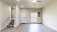 This two-story residence offers a clean, neutral aesthetic with thoughtfully designed living spaces across both levels. The entry level welcomes you with light gray luxury vinyl plank flooring that extends through the main living areas, complemented by recessed lighting and ceiling fans. The living room is bright and open, featuring a front-facing window with blinds, a ceiling fan with light fixture, and an electrical panel neatly integrated into the wall.

The kitchen is well-appointed with crisp white cabinetry, dark granite countertops, and a full suite of stainless steel appliances, including a range, over-the-range microwave, dishwasher, and refrigerator. The layout provides generous counter and storage space in an efficient configuration.

Bedrooms are carpeted for comfort and include ceiling fans, windows for natural light, and closets with built-in rods. The bathrooms feature white cabinetry with dark granite countertops, undermount sinks, and tiled tub-shower combinations with clean, minimal finishes. Tile flooring adds durability to the bathroom spaces.

Throughout the home, a consistent neutral color palette of soft beige and white tones creates a bright, cohesive atmosphere. The open layout on the main level and well-proportioned rooms upstairs provide a functional and comfortable living environment.