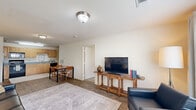 Located at 5005 Lake Park Dr in Wichita Falls, TX, this one-bedroom, one-bathroom unit offers a thoughtfully designed single-floor layout that maximizes every square foot of its compact footprint. The living room serves as the heart of the home, featuring warm wood-look flooring, neutral walls, and a large window that floods the space with natural light and offers views of the surrounding area. The open flow connects the living area seamlessly to the kitchen and dining space, making the layout feel open and functional. The kitchen is well-equipped with light maple cabinetry extending to the ceiling for generous storage, blue-gray countertops, a double-basin stainless steel sink, and a full suite of black appliances including a refrigerator, range, microwave, and dishwasher. A dedicated dining area with a wood table sits adjacent to the kitchen. The bedroom is a calm retreat with plush carpet flooring, two windows inviting natural light, and a dedicated closet for storage. The bathroom features a wood-toned vanity with a white countertop, wood-look tile flooring, and a full tub-shower combination. Neutral tones and consistent finishes throughout create a cohesive and comfortable living environment.