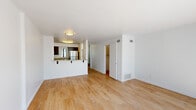 This well-designed two-bedroom, two-bathroom residence spans two floors, offering a functional and modern layout throughout. Light wood flooring flows consistently across both levels, lending warmth and cohesion to the interior.

The main level features an open living area bathed in natural light, with sliding glass doors that open to an outdoor view and fill the space with sunshine. A half-wall separates the living area from the kitchen, which is equipped with rich dark-wood cabinetry, granite countertops, stainless steel appliances including a gas range with microwave, and a breakfast bar for casual dining.

The upper level houses the two bedrooms, each finished with the same warm wood flooring and crisp white walls. The primary bedroom offers generous proportions with a walk-in closet and large windows showcasing sweeping panoramic views of the surrounding landscape. The second bedroom also benefits from natural light and outdoor views. Three closets provide ample storage throughout the residence.

Both bathrooms are finished with granite-topped vanities and dark wood cabinetry. One bathroom features a tub-shower combination with sliding glass doors, while the second offers a clean, minimalist design. A staircase connects the two floors, and a hallway facilitates smooth circulation. The overall ambiance is bright, clean, and contemporary.