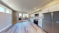Located at 1235 Oakmead Pkwy in Sunnyvale, CA, this single-floor space offers a contemporary, open-concept design characterized by clean lines and a bright, airy atmosphere. Light wood-look flooring runs consistently throughout the unit, providing a cohesive and modern aesthetic.

The kitchen is a standout feature, outfitted with crisp white shaker-style cabinetry extending to the ceiling for generous storage. A white subway tile backsplash complements the bright countertops, while a full suite of stainless steel appliances—including a refrigerator, electric range, built-in microwave, and dishwasher—provides a polished, functional cooking space. A stainless steel undermount sink with a contemporary faucet anchors the workspace.

The open living area adjoins the kitchen seamlessly, benefiting from recessed lighting and neutral-toned walls. A set of glass-paned doors leads directly to a private balcony, allowing natural light to fill the space and offering outdoor views of the surrounding community.

The bathroom maintains the same modern aesthetic, featuring a white vanity with a clean countertop, a mirror, and wood-look flooring that ties back to the rest of the unit. Closet storage is also present, adding practical functionality to the overall layout.