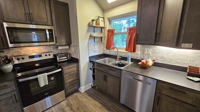 Spacious kitchen with brand-new, stainless appliances, extra-tall cabinets, composite countertops. - 502 Arbutus Ave SE