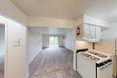 Located at 898 E Grand River Rd in Brighton, MI, this single-floor, one-bedroom, one-bathroom unit offers a well-organized and functional layout. The living room is generously sized, featuring soft carpeting, bright white walls, and a sliding glass door that opens to a private balcony with outdoor views of surrounding greenery—filling the space with natural light. The galley-style kitchen is efficiently designed with ample upper and lower cabinetry in white, a gas range, a refrigerator, a single-basin sink, and tile flooring that extends into the adjacent dining area. A ceiling fan overhead adds comfort to the dining space, which also includes a louvered closet door for additional storage. The bedroom is a comfortable, well-proportioned room with plush carpeting, a large window fitted with vertical blinds that invite natural light, and a built-in double closet offering generous storage. The full bathroom features a tub/shower combination, a vanity with sink, and tile flooring. Additional highlights include three closets throughout the unit, a dedicated utility room, and a connecting hallway that ties the layout together cohesively. The clean, neutral palette throughout creates a bright and welcoming atmosphere.