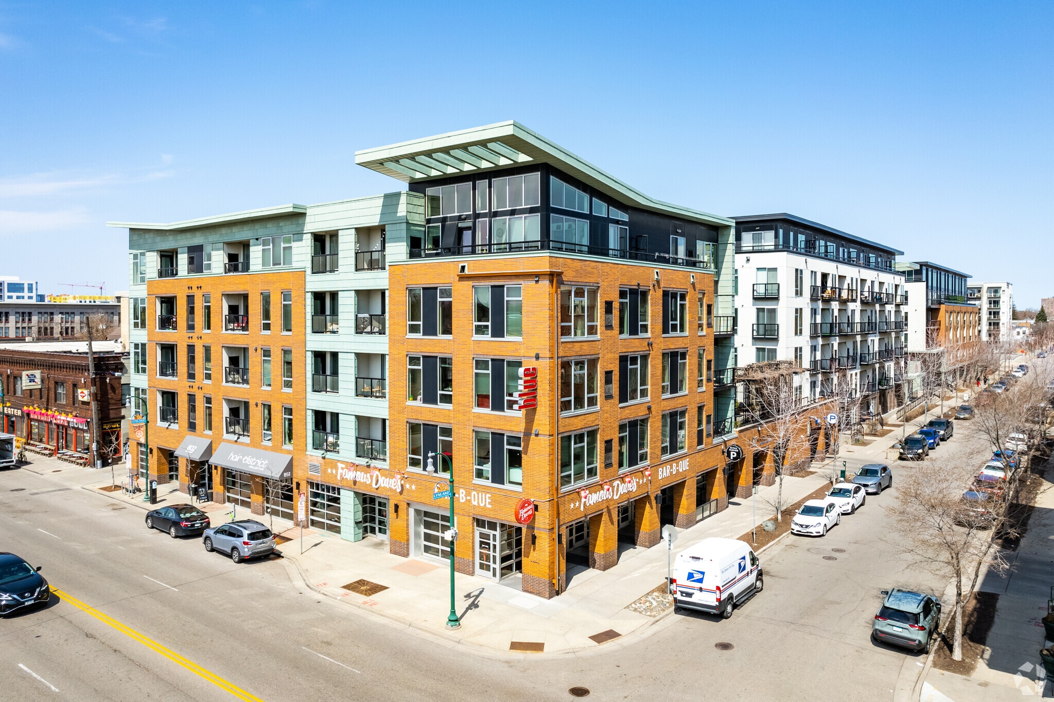 Exterior view of a modern apartment building with brick and light blue siding.