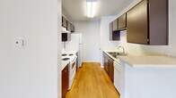 Located at 803 Flame Cir in San Antonio, TX, this single-story residence offers a practical and comfortable layout across a compact but well-utilized footprint. The living area is bright and open, featuring plush carpeting, neutral light gray walls, and a textured ceiling. Natural light pours in through a large window and a sliding glass door that opens to the outdoors, creating an airy and welcoming atmosphere.

The galley-style kitchen is efficiently designed with dark espresso cabinetry lining both sides, providing generous storage space. White appliances — including a range, refrigerator, and dishwasher — complement the light countertops, while warm hardwood-style flooring adds a touch of warmth. A flush-mount ceiling light keeps the space well-lit throughout.

The spacious bedroom is generously sized, offering a comfortable retreat with soft carpeting, a ceiling fan with integrated light fixture, and a large window that invites natural light. A sliding-door closet provides practical storage, keeping the room clean and organized.

Throughout the home, a consistent palette of soft whites and light neutrals creates a cohesive, move-in-ready feel. The functional single-floor layout makes navigation intuitive, and the overall design balances simplicity with everyday livability.