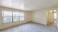 Located at 5300 Eubank Blvd NE in Albuquerque, New Mexico, this single-floor unit offers three bedrooms, two full bathrooms, a kitchen, and a connecting hallway. The layout is efficient and well-organized, making practical use of the available space throughout.

The bedrooms feature soft wall-to-wall carpeting and warm neutral tones. The generously sized primary bedroom includes a sliding-door closet and a window fitted with vertical blinds that allow natural light to filter in. The secondary bedrooms are similarly appointed, each with carpeted floors, white paneled doors, and closet access.

The kitchen is equipped with warm wood-toned cabinetry lining both sides of the galley-style layout, offering ample storage. It includes a double-basin sink, an electric coil range, a dishwasher, a refrigerator, and a built-in microwave. Countertops are finished in a dark laminate, and the flooring is wood-look vinyl plank. A peninsula counter connects the kitchen to the adjacent living area, enhancing the sense of openness.

Both bathrooms feature a clean white tub-shower combination with a full surround, complemented by warm beige walls and hard-surface flooring. Overall, the unit presents a functional and tidy living environment with a consistent neutral palette throughout.