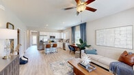 Located at 24 Winnow Walk in Wilmington, NC, this single-story, three-bedroom, two-bathroom home offers a well-designed open-concept layout filled with natural light and modern finishes throughout. Light-toned hardwood-style flooring runs through the main living areas, complementing the neutral color palette and creating a warm, cohesive ambiance.

The combined kitchen and living room serves as the heart of the home. The kitchen features white shaker cabinetry, granite countertops, stainless steel appliances, and a peninsula with bar seating — ideal for casual dining. The living area is anchored by a ceiling fan and connects seamlessly to a dining nook with natural light from window treatments framed in blue curtains.

The primary bedroom is generously sized, showcasing a tray ceiling, a large window with outdoor views, and a walk-in closet with built-in shelving and hanging rods. Two additional bedrooms offer comfortable accommodations with carpeted floors and ample natural light. A dedicated office includes built-in shelving, providing a functional workspace.

A full laundry room accommodates a side-by-side washer and dryer. The hallway features panel-style interior doors and clean, modern trim throughout. With its thoughtful layout, dedicated office, and quality finishes, this home offers both practicality and comfort in a desirable Wilmington location.