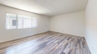 Located on Anza Avenue in Torrance, California, this single-floor, two-bedroom, two-bathroom residence offers a clean, functional layout designed for comfortable everyday living. The open living area is finished with light wood-style flooring that extends throughout the main spaces, while multiple windows dressed with vertical blinds allow natural light to fill the room. A textured ceiling adds a classic touch throughout the home. The kitchen is efficiently designed with white cabinetry, light countertops, a range with overhead ventilation, and matching wood-style flooring, providing a bright and practical cooking space. Both bedrooms feature soft wall-to-wall carpeting and sliding closet doors for storage, with windows that bring in natural light and views of the surrounding neighborhood. A hallway connects the private areas of the home. The two bathrooms are finished in a clean, minimal style — one features a floating vanity with a wide mirror and a towel bar, while the second includes a full tub-shower combination with white tile surround, a vanity, and illuminated mirror. Wood-style flooring is carried through both bathrooms, maintaining a cohesive aesthetic throughout the home. The overall ambiance is bright, neutral, and move-in ready.