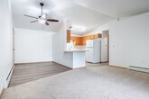 Located at 515 S 68th Ave in Wausau, Wisconsin, this one-bedroom, one-bathroom unit offers a well-organized single-floor layout with a clean, neutral aesthetic throughout. The open-concept living and kitchen area forms the heart of the unit, where light-tone laminate flooring transitions to plush carpeting in the living space. A ceiling fan with light fixture anchors the room, while a sliding glass door dressed with vertical blinds fills the area with natural light and provides outdoor views. A built-in breakfast bar neatly separates the kitchen from the living area, offering a casual dining option. The kitchen features warm oak cabinetry, white appliances including a range, over-the-range microwave, and refrigerator, along with a double sink and ample counter space. The generously sized bedroom is carpeted and includes a ceiling fan, a window with natural light, and access to a spacious walk-in closet fitted with wire shelving for organized storage. The bathroom is appointed with warm oak cabinetry, a wide vanity with a single sink, a large mirror, and light-tone vinyl flooring. Baseboard heating is present throughout the unit, ensuring comfort year-round. The overall ambiance is bright, clean, and functional.