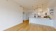 Located at 8205 Commerce Way in Miami Lakes, FL, this modern 2-bedroom, 2-bathroom residence offers a well-designed open-concept layout spread across a single living floor. Light wood flooring flows seamlessly throughout every room, creating a warm and cohesive aesthetic. The combined kitchen and living area serves as the heart of the home, anchored by a sleek kitchen featuring floor-to-ceiling white cabinetry, stainless steel appliances, a subway tile backsplash, a large peninsula with quartz countertops, and stylish pendant lighting overhead. The living area is bright and airy, highlighted by a sliding glass door that opens to a private balcony, allowing abundant natural light and outdoor views to fill the space. The spacious primary bedroom features large black-framed windows with views of the surrounding neighborhood and direct access to the balcony via a sliding door. The second bedroom is equally well-lit, with a wide window framing outdoor views. A dedicated walk-in closet offers generous storage. The bathrooms are finished with clean, modern fixtures, white vanities, and glass-enclosed showers. Throughout the residence, crisp white walls, clean lines, and thoughtful design details contribute to a bright, contemporary ambiance.