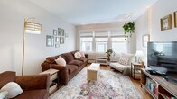 Located on University Avenue SE in Minneapolis, this two-bedroom, one-bathroom unit offers a well-organized, single-floor layout with hardwood flooring throughout. An entry hallway with a sliding barn-style door and a stylish pendant light provides a welcoming transition into the main living areas.

The living room is the heart of the unit, featuring a bank of large windows that flood the space with natural light. The kitchen has been thoughtfully updated with grey shaker-style cabinetry, white quartz countertops, a classic subway tile backsplash, and a stainless steel double-basin sink. Adjacent to the kitchen is a dedicated laundry area, adding everyday convenience.

Both bedrooms are comfortably proportioned with hardwood floors, windows overlooking the surrounding neighborhood, and ample closet space. The primary bedroom includes a sliding double-door closet and a ceiling fan, while the second bedroom features warm sage-green walls and a large window.

The bathroom is bright and clean, finished with white tile flooring, a grey vanity with white countertop, and a tub-shower combination. Throughout the unit, wood-toned doors and trim add warmth and continuity to the overall design. The space offers practical, comfortable city living in a well-connected Minneapolis neighborhood.