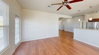 Located at 1600 Marina Rd in Irmo, SC, this single-floor, 2-bedroom, 2-bathroom residence offers a thoughtfully designed layout with a clean, neutral aesthetic throughout. The living room serves as the central gathering space, featuring warm hardwood-style flooring, crown molding, a ceiling fan, and large windows with exterior door access, flooding the room with natural light and outdoor views of surrounding greenery. The adjacent kitchen is well-equipped with stainless steel appliances, including a refrigerator, range, and built-in microwave, complemented by rich dark cabinetry, light countertops, track lighting, and hardwood-style flooring.

Both bedrooms are carpeted and include ceiling fans. The primary bedroom offers a generous footprint with a large window framing outdoor views, while the second bedroom similarly benefits from natural light. Each bedroom is serviced by its own full bathroom, both consistently finished with tile flooring, dark wood vanity cabinetry, light countertops, a tub-shower combination, and a large mirror. A hallway connects the bedrooms, and two closets provide practical storage throughout the residence.