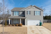 This well-appointed two-story home offers generous living space across two floors, providing ample room for comfortable living. The main level features an open-concept kitchen and living area, a dedicated dining room, and a welcoming entrance. The kitchen stands out with crisp white cabinetry, granite countertops, stainless steel appliances including a French door refrigerator and range, a central island with a sink, and recessed lighting — all complemented by warm hardwood-style flooring that flows throughout the home.

The upper floor hosts the majority of the five bedrooms, including a spacious primary suite. Bedrooms are bright and clean, featuring natural light from windows and ceiling fans where applicable. The home includes six full bathrooms finished with neutral tile flooring and tub-shower combinations. Eight closets are distributed throughout, offering exceptional storage, including walk-in closets with wire shelving systems.

Additional highlights include a dedicated laundry room equipped with a full-size washer and dryer, two hallways connecting the living areas seamlessly, and an attached garage with interior access. The consistent use of light neutral tones, clean white trim, and hardwood-style flooring gives the entire home a cohesive, modern aesthetic.