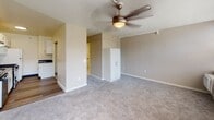 Located at 660 Boas St in Harrisburg, Pennsylvania, this single-floor residence offers a thoughtfully designed layout that balances functionality with comfortable living. The kitchen is a standout feature, outfitted with crisp white shaker cabinetry, dark granite countertops, and hardwood-style flooring. Stainless steel appliances — including a gas range, dishwasher, and refrigerator — provide a modern, cohesive look, while ample cabinet storage and a stainless steel sink add to the kitchen's practicality. The living and sleeping areas are finished with plush wall-to-wall carpeting and feature ceiling fans for year-round comfort. A generous bank of windows floods the space with natural light and frames views of the surrounding Harrisburg cityscape, creating an open, airy atmosphere. The bathroom is designed with accessibility in mind, featuring grab bars in the roll-in shower, a wall-mounted mirror cabinet, and classic mosaic tile flooring. A built-in storage unit within the main living area adds convenient organizational space. The overall design is clean and neutral, with warm beige tones, white trim, and baseboard heating throughout, making this a practical and comfortable space in the heart of Harrisburg.