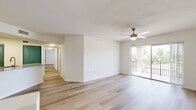 Located at 1601 S Hiatus Rd in Pembroke Pines, FL, this single-floor, 5-bedroom, 2-bathroom home offers a well-organized layout designed for comfortable living. Light wood-tone flooring flows consistently throughout, creating a bright and cohesive aesthetic.

The open living room is spacious and airy, featuring a ceiling fan and sliding glass doors that lead to a private balcony with views of surrounding palm trees and greenery. A vibrant teal entry door adds a distinctive design touch to the living area.

The kitchen is well-appointed with white shaker-style cabinetry, granite countertops, a teal subway tile backsplash, and a full suite of stainless steel appliances including a refrigerator, range, and microwave. A peninsula counter provides additional prep and serving space, and louvered teal accent doors add character throughout.

Each of the five bedrooms is filled with natural light from large windows with views of mature trees, and each is outfitted with a ceiling fan. The primary bedroom offers generous space. Both bathrooms feature granite-topped vanities, white tile tub-shower combinations, and wood-tone flooring. A dedicated laundry room and two closets — including a well-organized walk-in with wire shelving systems — round out the functional layout of this home.