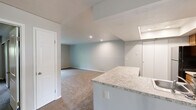 This single-story, 3-bedroom, 2-bathroom home offers a practical and well-organized layout designed to maximize every square foot. The open-concept kitchen and living area serves as the heart of the home, where a peninsula with light granite-look countertops separates the kitchen from the carpeted living space. The kitchen is equipped with warm wood-toned cabinetry, black appliances including a refrigerator, range, and microwave, as well as wood-look flooring and a recessed ceiling detail that adds a subtle architectural touch. A skylight above the kitchen peninsula brings in additional natural light.

The living room is generously proportioned, featuring neutral carpet and a sliding glass door that opens to a green outdoor area, filling the space with natural light and offering easy outdoor access. The three bedrooms are carpeted and finished with neutral tones throughout. The spacious primary bedroom includes a walk-in closet with built-in shelving and a window overlooking the exterior. The two bathrooms each feature a tub-shower combo with brushed nickel fixtures. A connecting hallway ties the layout together efficiently. Overall, the home presents a clean, move-in-ready interior with consistent finishes throughout.