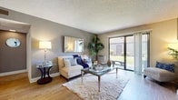 Located at 1300 Adams Ave in Costa Mesa, California, this 2-bedroom, 3-bathroom single-story home offers a well-designed layout across a comfortable footprint. The living room is a standout space, featuring light wood-style flooring, a textured ceiling, a fireplace with a mounted TV above, and sliding glass doors that open to a private outdoor area, filling the room with natural light and views of a lush green exterior. The adjacent dining area connects seamlessly to the kitchen, which is equipped with warm wood cabinetry, granite-style countertops, a double sink, and a peninsula with bar seating — ideal for casual dining. The spacious primary bedroom features plush carpeting, dual mirrored sliding closets offering generous storage, and direct access to a dedicated bathroom with a granite-topped vanity and a walk-in shower. The second bedroom is carpeted and well-proportioned, with its own bathroom access. All three bathrooms are finished with wood cabinetry and granite-style countertops, maintaining a consistent design aesthetic throughout. The overall ambiance of the home is neutral and inviting, with warm tones, practical finishes, and a functional flow that suits everyday living in the heart of Orange County.