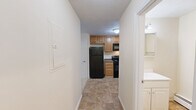 Located at 106 W River Dr in Manchester, NH, this one-bedroom, one-bathroom unit offers a practical and well-organized single-floor layout. The space includes two living areas, providing flexibility for both a dedicated living room and a separate dining or sitting area. One living space features a window unit for climate control, baseboard heating, and a natural light-filled window with outdoor views, while the second living area is accented by a classic chandelier overhead — both finished with neutral carpet flooring and warm beige walls throughout.

The kitchen is efficiently designed with warm wood cabinetry, dark granite-style countertops, tile flooring, and a full suite of black appliances including an electric range, built-in microwave, dishwasher, and a stainless steel sink — making it a fully functional cooking space.

The bedroom offers a comfortable, carpeted retreat with a spacious closet featuring sliding panel doors and baseboard heating. The bathroom includes a full tub and shower combo with clean white tile surround and tile flooring, maintaining a simple and functional aesthetic.

Throughout the unit, the consistent use of neutral tones, carpet, and baseboard heating creates a cohesive and low-maintenance living environment.