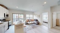 Located at 4009 Fulton Ct in Cleveland's Ohio City neighborhood, this single-floor unit offers a clean, contemporary design characterized by light-toned finishes, recessed lighting, and light-washed hardwood flooring that flows through the main living areas.

The open-concept layout connects the kitchen, dining, and living areas seamlessly. The kitchen is equipped with stainless steel appliances—including a refrigerator, dishwasher, range, and built-in microwave—paired with two-tone cabinetry featuring white upper cabinets and warm wood lower cabinets, complemented by white quartz countertops and a subway tile backsplash. A breakfast bar with seating provides additional dining space.

The living area is bright and airy, with multiple windows allowing generous natural light and direct access to a private balcony offering neighborhood views. The space accommodates comfortable seating and opens to the bedroom wing.

Both bedrooms feature plush carpeting, ample natural light from large windows, and closet storage. The bathroom is finished with large-format wood-look tile in the walk-in shower, a floating vanity with quartz countertop, and an illuminated mirror, creating a polished, spa-like atmosphere.