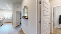 Located at 4902 Cosmos Cir in Wimauma, FL, this single-floor, 2-bedroom, 2-bathroom home offers a thoughtfully laid-out interior with modern finishes throughout. The welcoming entryway features wood-look flooring, neutral walls, and a decorative arched mirror with a floating shelf, setting a clean, contemporary tone.

The living room is a bright, inviting space bathed in natural light from a large bank of windows dressed with plantation shutters and floor-length drapes. The kitchen is well-appointed with white shaker-style cabinetry, light countertops, a subway tile backsplash, and a full suite of stainless steel appliances, including a refrigerator, range, and microwave. Wood-look flooring continues throughout, adding warmth and cohesion.

The primary bedroom is a comfortable retreat with large windows, soft natural light, and room for a full furniture arrangement. The second bedroom also features a window with ample natural light. Both bathrooms are finished with white vanity cabinetry and wood-look tile flooring; one includes a tub-shower combination with built-in shelving.

A dedicated laundry room houses a full-size top-loading washer and dryer with wire shelving above. Two closets provide generous storage, including a walk-in closet with wire shelving systems. The overall ambiance is bright, clean, and move-in ready.