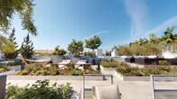 Located at 1120 W 6th St in the heart of Downtown Los Angeles, this beautifully designed rooftop terrace offers a lush, resort-inspired outdoor retreat with stunning panoramic views of the city skyline. The space is thoughtfully landscaped with towering palm trees, manicured hedges, ornamental grasses, colorful flowering plants, and sculptural succulents arranged throughout raised white planter beds, creating a verdant urban oasis. Multiple distinct zones make this terrace highly functional and inviting. A shaded outdoor dining area, covered by a sail canopy strung with bistro lights, features a large wooden dining table with woven seating and a built-in grill station — ideal for al fresco entertaining. Nearby, open-air lounge areas are furnished with comfortable seating and hammocks, surrounded by lush greenery that provides both shade and privacy. Crisp, modern paving tiles tie the entire terrace together with a clean, contemporary aesthetic. A dedicated pet relief area with fenced enclosure adds a practical amenity. Throughout the terrace, unobstructed sightlines reveal the iconic Downtown LA skyline, including prominent high-rise towers, offering a dramatic urban backdrop that defines this exceptional outdoor space.