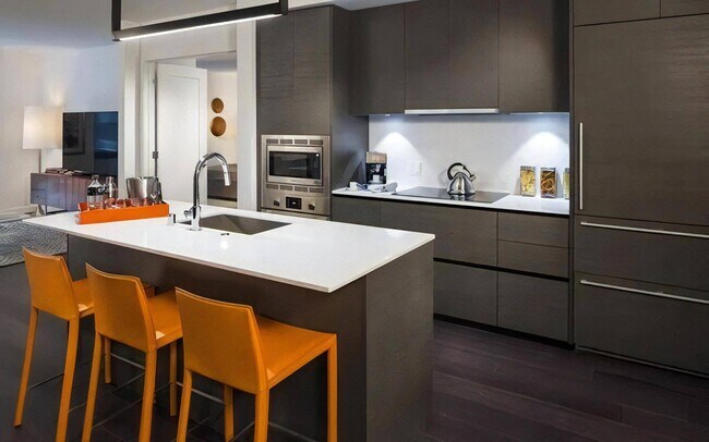 Cocina de pared completa con gabinetes superiores e inferiores e iluminación debajo de los gabinetes - Pike Motorworks