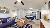This two-bedroom, two-bathroom residence in Phoenix, Arizona offers a well-designed single-level floor plan that makes efficient use of its space. The open-concept living and dining area is bright and welcoming, featuring wood-look vinyl flooring, a ceiling fan, and a large window that brings in natural light. The living area flows directly into the dining space and kitchen, creating a cohesive entertaining zone. The kitchen is equipped with stainless steel appliances—including a refrigerator, range, and microwave—complemented by white upper cabinetry, contrasting lower cabinets, and a classic subway tile backsplash. Both bedrooms are comfortably sized, each featuring ceiling fans, plush carpeting, and windows with blinds. The two bathrooms are clean and functional, with white vanity cabinetry and light quartz-style countertops. A standout feature of this residence is the in-unit washer and dryer, conveniently housed within the second bathroom. The overall aesthetic is modern and neutral, with light tones throughout creating a cohesive and airy ambiance. Located at 6405 W McDowell Rd, this home offers practical, comfortable living in the heart of Phoenix.