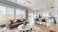 This single-story residence showcases a thoughtfully designed open-concept layout that seamlessly connects the living, dining, and kitchen areas. The living room is a welcoming space anchored by large windows that flood the interior with natural light, complemented by a ceiling fan overhead and a sliding glass door leading to an outdoor patio. A sage-green accent wall adorned with framed botanical artwork adds a distinctive design touch, while wood-look flooring runs consistently throughout the home.

The kitchen is well-appointed with white shaker-style cabinetry, granite countertops, stainless steel appliances including a refrigerator, range, and built-in microwave, and a peninsula with bar seating that doubles as a casual dining area.

The bedrooms feature the same warm wood-look flooring, neutral two-tone wall treatments, and windows that invite natural light. The primary bedroom includes a walk-in closet with built-in shelving and hanging storage, along with an en-suite bathroom featuring granite countertops, white cabinetry, and a large mirror. A secondary bathroom mirrors the same clean, modern finishes. Built-in shelving near the living area provides additional display and storage space, contributing to the home's functional yet polished aesthetic.
