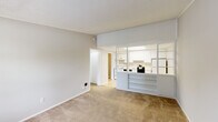 Located at 6041 Ullyot Dr in Fort Wayne, Indiana, this efficiently designed one-bedroom, one-bathroom unit offers a practical and functional single-floor layout. The open-concept living area features neutral-toned carpet and a textured ceiling, creating a clean and understated atmosphere. A distinctive pass-through with built-in shelving connects the living space to the kitchen, enhancing the sense of openness. The kitchen is outfitted with white cabinetry extending to the ceiling for ample storage, light countertops, a stainless steel sink, and a full suite of white appliances including an electric range, dishwasher, and refrigerator. Tile flooring and a recessed ceiling light fixture complete the kitchen's practical design. The bedroom is a comfortable size, featuring carpet flooring, crown molding, a textured ceiling, and a window with blinds that allows natural light and outdoor views. The full bathroom includes a tub-shower combination, a marble-patterned vanity countertop, a mirror, and tile flooring. A dedicated laundry room provides added convenience with space for a full-size washer and dryer alongside a water heater. The hallway connects all rooms efficiently, making this a well-organized and functional living space.