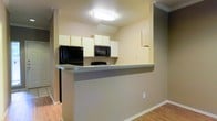 This two-floor residence offers a straightforward and functional layout designed for comfortable everyday living. The kitchen is a standout feature, designed with an open-concept approach that connects seamlessly to the adjacent living area. A peninsula-style breakfast bar extends outward, providing additional counter space and a casual dining option. White upper cabinetry lines the kitchen walls, offering ample storage, while black appliances — including a refrigerator and over-the-range microwave — provide a clean contrast against the light-toned walls and countertops. The kitchen benefits from flush ceiling lighting that keeps the space bright and well-illuminated. Warm-toned laminate flooring runs through the main areas, adding a sense of continuity and warmth to the interior. The neutral wall colors throughout create a versatile backdrop that adapts easily to a variety of décor styles. With two floors of living space, the home offers room separation that supports both shared living and private retreat. The overall ambiance is clean, practical, and move-in ready, making it a solid option for those seeking a well-organized and easy-to-maintain home environment.