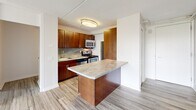 Located at 3610 Mystic Valley Pkwy in Medford, MA, this one-bedroom, one-bathroom unit offers a well-organized and efficient single-floor layout. Light-toned hardwood-style flooring runs throughout the space, providing a clean, cohesive aesthetic.

The kitchen is a standout feature, outfitted with rich warm-toned wood cabinetry, a tile backsplash, stainless steel appliances including a gas range, microwave, and refrigerator, and a peninsula with a stone-style countertop that provides additional prep space and serves as a natural divider between the kitchen and living area.

The bedroom is a comfortable size, featuring a large sliding-door closet for ample storage and a window that brings in natural light. The neutral white walls offer a versatile backdrop throughout the unit.

The bathroom is well-appointed with warm wood-toned cabinetry, a white countertop vanity, overhead storage cabinets, and a full soaking tub with shower. Wood-look tile flooring ties the room together with the rest of the unit.

A hallway connects the rooms efficiently, contributing to a practical and functional floor plan. The overall ambiance is clean, modern, and move-in ready, making it a comfortable residence in the Medford area.