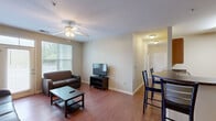 Located at 342 Walden Station Dr in Charlotte, NC, this single-floor, 2-bedroom, 2-bathroom residence offers a comfortable and functional layout. The living room serves as the heart of the home, featuring hardwood-style flooring, a ceiling fan, and large windows with a transom above the exterior door that fill the space with natural light and provide views of the surrounding greenery. A dining area sits adjacent, flowing seamlessly into the kitchen.

The galley-style kitchen is well-appointed with light wood cabinetry, dark countertops, and a full suite of stainless steel appliances including a gas range, microwave, dishwasher, and refrigerator. A curved breakfast bar with bar seating connects the kitchen to the dining and living areas, enhancing the open feel.

Both bedrooms are carpeted and equipped with ceiling fans. The spacious primary bedroom offers comfortable proportions, while the second bedroom provides ample room for flexible use. Each bathroom includes a full tub-shower combination, tile flooring, and warm neutral tones throughout.

Neutral wall colors, consistent flooring choices, and practical finishes give this residence a cohesive, move-in-ready appeal. The single-floor layout ensures easy navigation throughout the home.