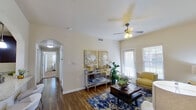 This single-floor residence offers a thoughtfully designed layout that balances comfort and functionality. The living room serves as the heart of the home, featuring warm hardwood flooring, a ceiling fan with light fixture, and abundant natural light streaming through multiple windows and a glass-paneled door leading to the outdoors. The space is open and inviting, anchored by a vibrant blue patterned area rug and complemented by an elegant arched entryway connecting to the hallway.

The galley-style kitchen is well-equipped with dark espresso cabinetry, light granite countertops, stainless steel appliances including a range, microwave, and double sink, all illuminated by track lighting overhead. Light wood-toned flooring runs throughout this space, adding warmth and continuity.

The bedrooms are carpeted and generously sized, each equipped with a ceiling fan and window treatments that allow for ample natural light. One bedroom features a versatile daybed setup, while another offers a more traditional layout with a wooden dresser and decorative mirror.

Both bathrooms maintain a cohesive aesthetic with dark cabinetry, granite-style countertops, tile flooring, and large vanity mirrors. One bathroom includes a walk-in shower, while the other features a shower-tub combo. Together, the spaces reflect a clean, well-maintained interior with consistent design choices throughout.