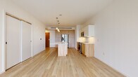 Located at 515 Euclid Ave in the heart of Cleveland, OH, this modern single-floor unit offers a thoughtfully designed open-concept layout with clean lines and contemporary finishes throughout. Light hardwood flooring runs seamlessly across the main living areas, creating a warm, cohesive aesthetic.

The kitchen is a standout feature, anchored by a generous island with a white quartz countertop and natural wood base cabinetry. White upper cabinets complement the warm wood-toned lower cabinetry, and stainless steel appliances — including a French door refrigerator, range, and microwave — complete the space. Pendant lighting above the island adds a refined touch.

The open living area is bathed in natural light from large floor-to-ceiling windows that frame elevated views of the Cleveland cityscape, lending the space an airy, expansive feel. A pendant light fixture anchors the living area, while the generous floor plan offers flexible arrangement possibilities.

The bathroom features a clean, minimalist design with dark hardwood flooring, a soaking tub and shower combination, and warm wood-toned vanity cabinetry. White walls throughout maintain a bright, neutral palette that highlights the quality of the finishes. This well-appointed unit combines modern urban design with functional living in a prime Cleveland location.