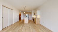 Located at 515 Euclid Ave in the heart of Cleveland, OH, this modern single-floor unit offers a thoughtfully designed open-concept layout with clean lines and contemporary finishes throughout. Light hardwood flooring runs seamlessly across the main living areas, creating a warm, cohesive aesthetic.

The kitchen is a standout feature, anchored by a generous island with a white quartz countertop and natural wood base cabinetry. White upper cabinets complement the warm wood-toned lower cabinetry, and stainless steel appliances — including a French door refrigerator, range, and microwave — complete the space. Pendant lighting above the island adds a refined touch.

The open living area is bathed in natural light from large floor-to-ceiling windows that frame elevated views of the Cleveland cityscape, lending the space an airy, expansive feel. A pendant light fixture anchors the living area, while the generous floor plan offers flexible arrangement possibilities.

The bathroom features a clean, minimalist design with dark hardwood flooring, a soaking tub and shower combination, and warm wood-toned vanity cabinetry. White walls throughout maintain a bright, neutral palette that highlights the quality of the finishes. This well-appointed unit combines modern urban design with functional living in a prime Cleveland location.