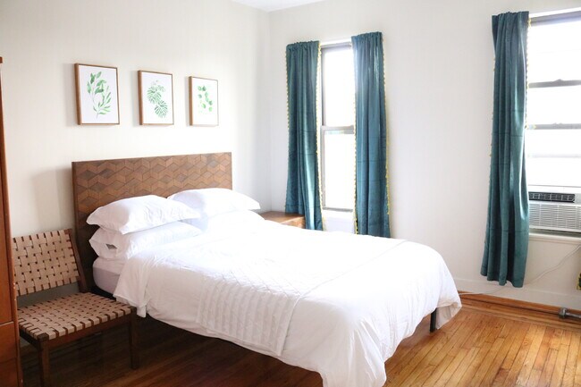 Bedroom 3: Ceiling fan, TV, large windows. - 664 Manhattan Ave