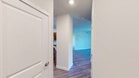 Located at Riverside Plaza in Millsboro, Delaware, this single-floor, 2-bedroom, 2-bathroom residence offers a thoughtfully designed layout with a clean, modern aesthetic throughout. The open-concept kitchen and living area serves as the heart of the home, where rich espresso-toned cabinetry, granite countertops, a central island with a sink, and a full suite of stainless steel appliances — including a refrigerator, range, and microwave — create a functional and stylish cooking space. Recessed lighting illuminates the kitchen, while durable wood-look flooring extends through the main living areas. The living room provides sliding glass door access to an outdoor space, filling the room with natural light and views of the surrounding community. Both bedrooms are carpeted for comfort, with the generously sized primary bedroom featuring a window with natural light. The second bedroom is also well-proportioned and similarly finished. Two dedicated closets offer practical storage, including a walk-in style closet with wire shelving. The two bathrooms are clean and functional, one featuring a soaking tub and shower combination and the other a standalone shower unit, both with brushed nickel fixtures.