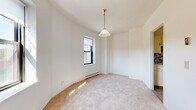 Located at 12506 Edgewater Dr in Lakewood, OH, this single-floor, three-bedroom, one-bathroom unit offers a functional and straightforward layout. The space is finished throughout with neutral wall-to-wall carpeting, creating a cohesive and understated aesthetic across the bedrooms.

The generously sized primary bedroom features crown molding, large windows that invite ample natural light, and a baseboard heating system. The two additional bedrooms are well-proportioned — one is brightened by a pendant light fixture and multiple windows with outdoor views of the surrounding neighborhood, while the other offers a quieter, more compact feel with its own window and baseboard heater.

The kitchen is equipped with white cabinetry, a marble-style countertop, an electric range, and a mosaic tile backsplash in muted tones that adds a modern accent. The flooring transitions to tile in this area, making it both practical and easy to maintain.

The bathroom showcases classic vintage character, featuring white subway tile walls with black accent trim, a hexagonal mosaic tile floor with decorative detailing, a pedestal sink, a soaking tub with a shower, and a mirrored medicine cabinet above. A hallway connects the rooms, completing the efficient and well-organized floor plan.