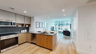 Located at 5 Cottage Place in White Plains, NY, this thoughtfully designed two-bedroom, two-bathroom residence offers a seamless blend of modern aesthetics and functional living. Light hardwood flooring flows throughout the single-level layout, unifying each space cohesively.

The open-concept kitchen is a standout feature, showcasing warm wood cabinetry, dark stone countertops, stainless steel appliances, and a central island with bar seating — ideal for both casual dining and entertaining. The kitchen opens directly into the dining area and living room, which is bathed in natural light from expansive floor-to-ceiling windows offering sweeping urban views of White Plains.

The primary bedroom is generously proportioned, featuring large windows with city views and access to a dedicated walk-in closet with built-in shelving. The second bedroom also benefits from ample closet space. Both bathrooms are finished in a clean, contemporary style, with the full bath featuring large-format marble-look tile flooring, a glass-enclosed walk-in shower, and warm wood vanity cabinetry.

Additional highlights include three closets, a dedicated laundry area, and recessed lighting throughout. The residence offers a bright, airy ambiance with a refined modern character well-suited to urban living.