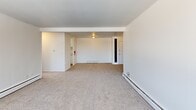 Located at 1305 S Congress St in Ypsilanti, Michigan, this two-bedroom, two-bathroom unit offers a functional and well-organized single-floor layout. The open living and dining areas are carpeted and bathed in natural light, creating a bright and welcoming atmosphere. Large windows throughout the unit frame outdoor views of the surrounding neighborhood, while baseboard heating runs along the perimeter of each room for consistent comfort.

The spacious primary bedroom features a wide picture window that fills the room with daylight and offers an elevated view of the streetscape. A generously sized second bedroom provides flexibility for guests or a home office. Three closets throughout the unit offer ample storage, complementing the practical layout.

The kitchen is finished in a clean, all-white palette with white cabinetry, marble-look countertops, and a full suite of white appliances including a coil-top range with overhead ventilation. Both bathrooms are bright and neatly appointed, with one featuring a full tub-shower combination, tile flooring, and a vanity with a marble-look countertop and mirrored medicine cabinet.

A private balcony accessible via sliding glass doors extends the living space outdoors. A dedicated utility room and additional storage areas round out this well-planned unit.