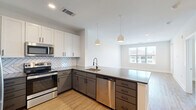 Located at 905 Lakeford Dr in Morrisville, NC, this well-designed 2-bedroom, 2-bathroom residence offers a thoughtful single-floor layout with contemporary finishes throughout. Light wood-look flooring flows seamlessly across the entire unit, creating a warm and cohesive aesthetic.

The open-concept kitchen and living area serves as the heart of the home. The kitchen features a two-tone design with white upper cabinets and gray lower cabinets, a herringbone tile backsplash, quartz countertops, stainless steel appliances including a refrigerator, range, microwave, and dishwasher, and pendant lighting over the peninsula — ideal for both cooking and entertaining.

The primary bedroom is a comfortable retreat with recessed lighting, large windows for natural light, and access to a well-organized walk-in closet with built-in shelving. Its en-suite bathroom includes a gray vanity with a white quartz countertop, a large framed mirror, and matte black fixtures. The second bedroom also features ample natural light and an outdoor view. The second bathroom offers a subway-tiled tub-shower combination, a matching gray vanity, and consistent matte black hardware. Additional conveniences include a dedicated laundry area, hallway, and two closets, rounding out this clean, modern residence.