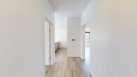 This thoughtfully designed two-bedroom, two-bathroom unit at 112 Webster Street in Dayton, Ohio offers a cohesive modern aesthetic across its single-floor layout. Light wood-style flooring flows consistently throughout, complementing the crisp white walls and creating a bright, clean atmosphere.

The kitchen serves as a focal point of the space, featuring a large center island with quartz countertops, warm wood cabinetry, and brushed gold hardware. Pendant lighting with gold-toned fixtures hangs above the island, and black-framed windows provide ample natural light and urban views. Stainless steel appliances, including a range and refrigerator, complete the functional design. A subtle tile backsplash adds texture behind the range wall.

Both bedrooms feature ceiling fans, light-toned built-in cabinetry for storage, and large windows that invite natural light. The primary bedroom offers a comfortable sense of space, while the second bedroom maintains the same clean, minimalist character.

The two bathrooms are finished with marble-look porcelain tile flooring and white subway tile surrounds. Brushed gold fixtures and hardware carry the unit's warm metallic theme into these rooms. One bathroom includes a glass-enclosed walk-in shower, while the other features a full tub with a frameless sliding glass enclosure.