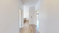 This thoughtfully designed two-bedroom, two-bathroom unit at 112 Webster Street in Dayton, Ohio offers a cohesive modern aesthetic across its single-floor layout. Light wood-style flooring flows consistently throughout, complementing the crisp white walls and creating a bright, clean atmosphere.

The kitchen serves as a focal point of the space, featuring a large center island with quartz countertops, warm wood cabinetry, and brushed gold hardware. Pendant lighting with gold-toned fixtures hangs above the island, and black-framed windows provide ample natural light and urban views. Stainless steel appliances, including a range and refrigerator, complete the functional design. A subtle tile backsplash adds texture behind the range wall.

Both bedrooms feature ceiling fans, light-toned built-in cabinetry for storage, and large windows that invite natural light. The primary bedroom offers a comfortable sense of space, while the second bedroom maintains the same clean, minimalist character.

The two bathrooms are finished with marble-look porcelain tile flooring and white subway tile surrounds. Brushed gold fixtures and hardware carry the unit's warm metallic theme into these rooms. One bathroom includes a glass-enclosed walk-in shower, while the other features a full tub with a frameless sliding glass enclosure.