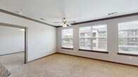 Located in Humble, TX, this thoughtfully designed single-floor residence offers two bedrooms, two bathrooms, and two closets within a comfortable, functional layout. The open kitchen is a standout feature, showcasing rich dark-stained cabinetry, granite countertops, a white tile backsplash, and a full suite of stainless steel appliances including a range, microwave, refrigerator, and dishwasher. Warm wood-look flooring runs throughout the kitchen, adding a cohesive, modern aesthetic. The spacious living area is bathed in natural light through a bank of three large windows fitted with blinds, and is finished with plush carpeting and a ceiling fan. The primary bedroom is generously sized, featuring carpet flooring, a ceiling fan, and a window with an outdoor view. Both bathrooms are well-finished with wood-look flooring, granite-topped dark vanities, and tiled soaking tub and shower combinations with brushed nickel fixtures. One bathroom features a double-sink vanity with a large mirror. Each bedroom is served by a dedicated closet with wire shelving systems that maximize storage. Neutral gray walls and dark baseboards create a clean, contemporary look throughout the entire home.