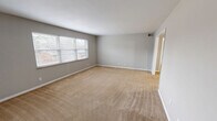 Located at 801 Gate Ln in Knoxville, Tennessee, this single-floor, 2-bedroom, 2-bathroom home offers a well-organized and functional layout. The living room is generously sized, featuring neutral gray walls, plush beige carpeting, and large windows that invite natural light and outdoor views. Adjacent to the living area, the dining room connects seamlessly to the galley-style kitchen, which is outfitted with white cabinetry, tile backsplash, dark countertops, a double sink, and white appliances, all set on hexagonal tile flooring. A pantry provides additional kitchen storage. The spacious primary bedroom includes its own closet and a private en-suite bathroom. The second bedroom is comfortably sized with a closet and window. Both bathrooms feature tile wainscoting with a clean, modern finish, and one includes a full soaking tub with a shower. Throughout the home, four closets offer exceptional storage. A dedicated laundry area and utility room add further convenience. The consistent use of soft gray tones, white trim, and carpeted bedrooms gives the home a cohesive and neutral aesthetic, ready for personalization.