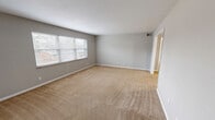 Located at 801 Gate Ln in Knoxville, Tennessee, this single-floor, 2-bedroom, 2-bathroom home offers a well-organized and functional layout. The living room is generously sized, featuring neutral gray walls, plush beige carpeting, and large windows that invite natural light and outdoor views. Adjacent to the living area, the dining room connects seamlessly to the galley-style kitchen, which is outfitted with white cabinetry, tile backsplash, dark countertops, a double sink, and white appliances, all set on hexagonal tile flooring. A pantry provides additional kitchen storage. The spacious primary bedroom includes its own closet and a private en-suite bathroom. The second bedroom is comfortably sized with a closet and window. Both bathrooms feature tile wainscoting with a clean, modern finish, and one includes a full soaking tub with a shower. Throughout the home, four closets offer exceptional storage. A dedicated laundry area and utility room add further convenience. The consistent use of soft gray tones, white trim, and carpeted bedrooms gives the home a cohesive and neutral aesthetic, ready for personalization.