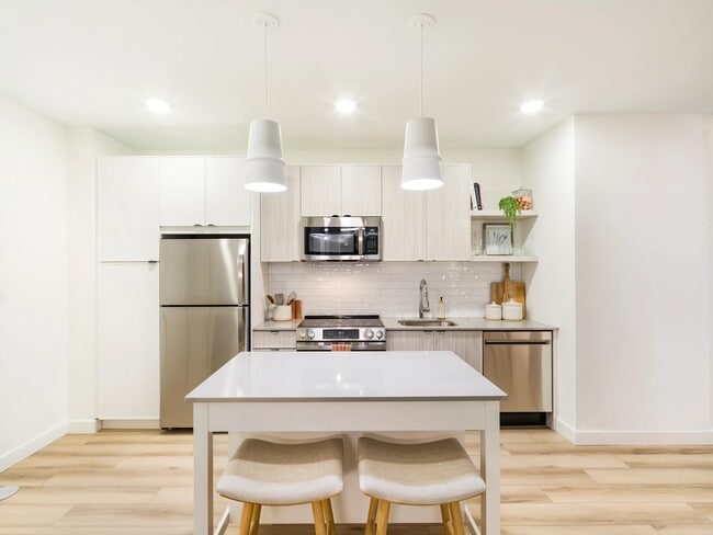 Una cocina funcional con líneas limpias, amplio espacio de almacenamiento y una isla versátil para comer a diario. - Modera Revere Beach