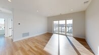 Located at 4 N Hickory Ave in Arlington Heights, IL, this thoughtfully designed 2-bedroom, 2-bathroom residence offers a clean, modern aesthetic throughout its well-appointed single-floor layout. Warm hardwood-style flooring flows seamlessly across the main living areas, complementing the bright, neutral palette of the interiors.

The open-concept living and dining area is bathed in natural light, thanks to expansive sliding glass doors that lead to a private balcony overlooking the surrounding neighborhood. Recessed lighting adds a polished finish to the space.

The galley-style kitchen is outfitted with stainless steel appliances, two-tone cabinetry pairing natural wood uppers with dark lower cabinets, and a sleek white countertop that extends to a peninsula with an undermount sink — ideal for both cooking and entertaining.

Both bedrooms feature hardwood-style flooring, ample closet space with double-door closets, and large windows that invite natural light. The primary bedroom offers a comfortable and private retreat.

The two bathrooms are finished with clean white tile work. One features a soaking tub with a bright window framing neighborhood views, while the other includes a glass-enclosed walk-in shower. In-unit laundry and multiple utility and storage spaces round out this well-equipped home.