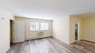 Located at 9 Zachary Lane in Trenton, NJ, this single-floor unit offers a clean, updated interior with a cohesive neutral color palette throughout. The living areas are finished with durable wood-look plank flooring in a warm gray-brown tone, complemented by crisp white trim and soft beige walls that create a bright, open atmosphere. Multiple windows fitted with horizontal blinds allow natural light to filter through the various rooms, enhancing the overall sense of space.

The living area is generously proportioned, featuring a wall-mounted air conditioning unit and baseboard heating for year-round climate control. Additional rooms reflect the same flooring and neutral tones, providing versatile spaces well-suited for a variety of uses. Each room benefits from natural light through large windows, contributing to the airy feel of the unit.

The kitchen is outfitted with gray shaker-style cabinetry, marble-look countertops, and stainless steel appliances including a gas range and over-the-range microwave, offering both style and practicality.

The bathroom stands out with floor-to-ceiling marble-look tile surrounding a soaking tub, paired with a window that brings in natural light, lending the space an elegant and polished character. Overall, the unit presents a well-maintained, move-in-ready interior with modern finishes throughout.